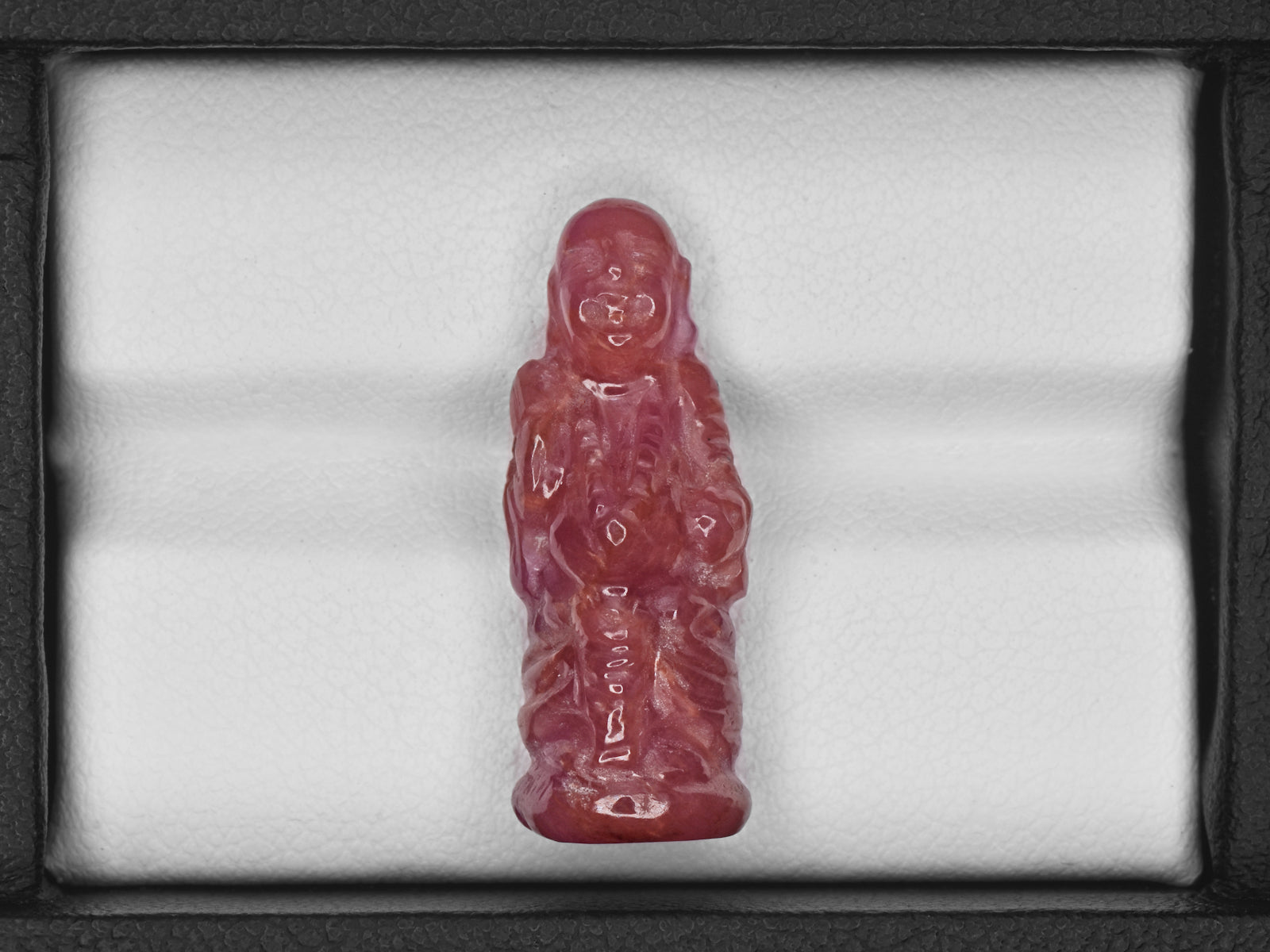 8801538-carved-pinkish-red-with-orange-staining-gii-guinea-natural-ruby-18.61-ct