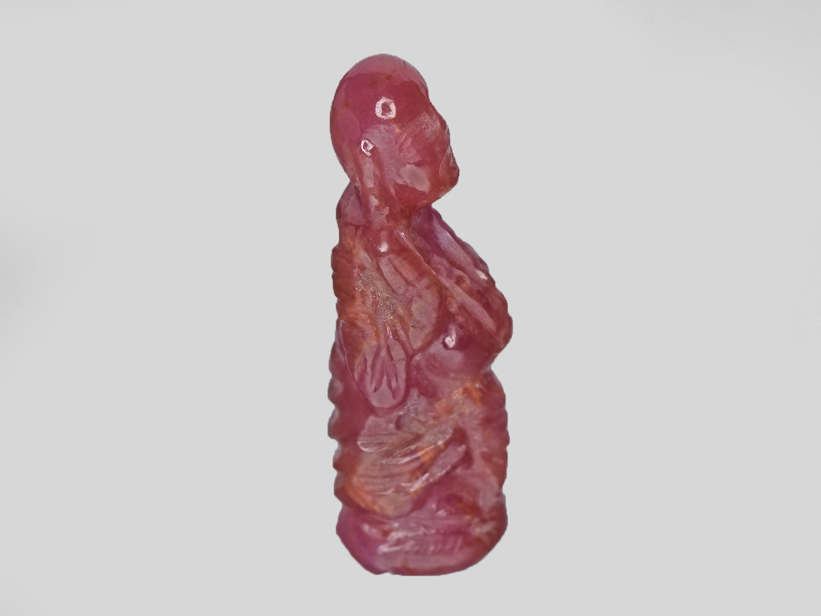 8801538-carved-pinkish-red-with-orange-staining-gii-guinea-natural-ruby-18.61-ct